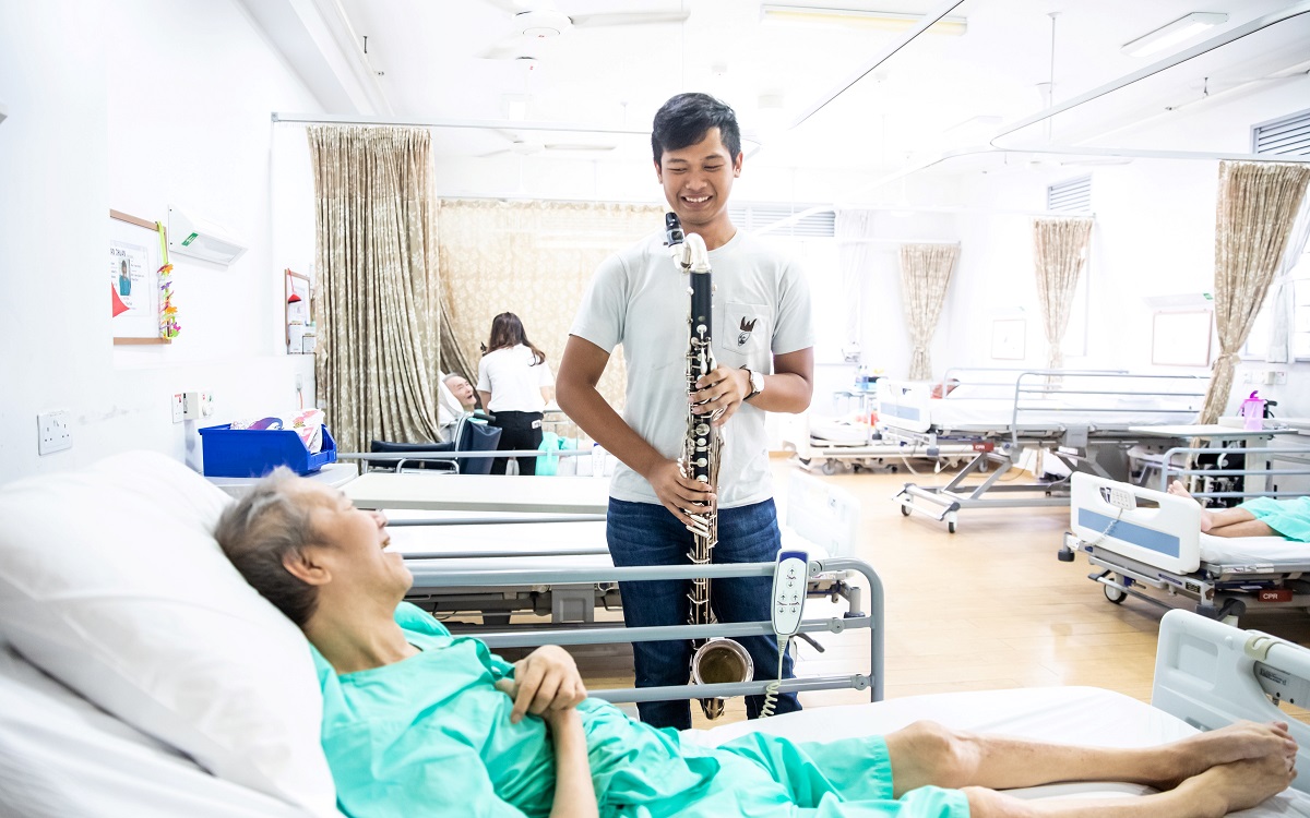 A bedside performance for a patient in a hospital ward.