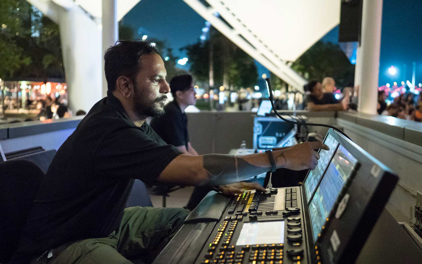 Image depicting a technician at the sound console at Esplanade Outdoor Theatre.