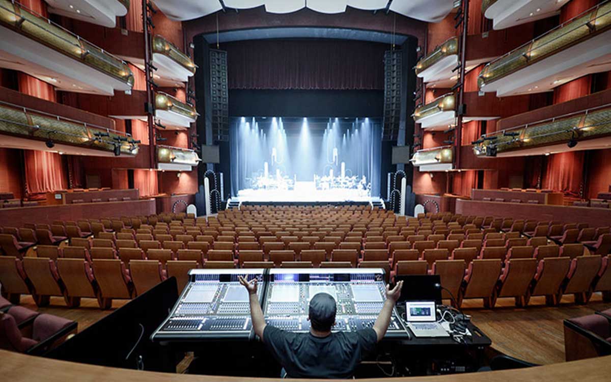 Image of interior of Esplanade Theatre with technician at the sound console.